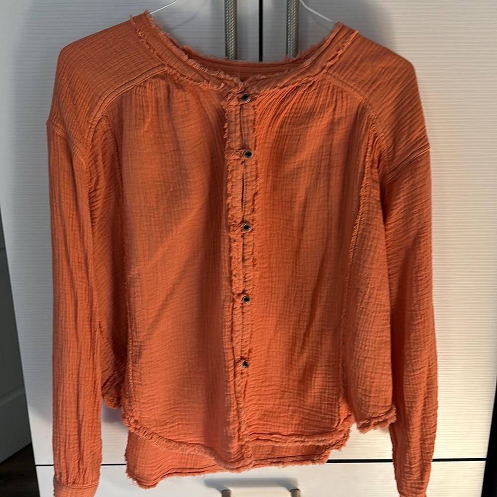 We the Free xs, definitely oversized. Soft orange light weight with buttons.
